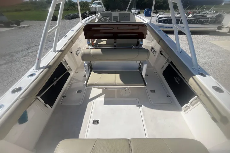Slide: The Image of 2016 Pursuit S 280 Sport boat interior with seating and console, docked outdoors. - 7