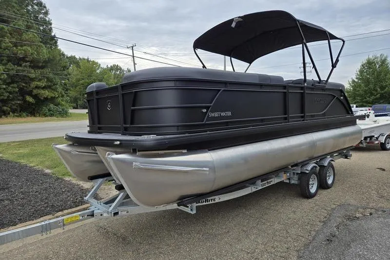 The Image of 2026 Godfrey SWEETWATER 2286 SB pontoon boat on trailer, black exterior, parked roadside. - 0