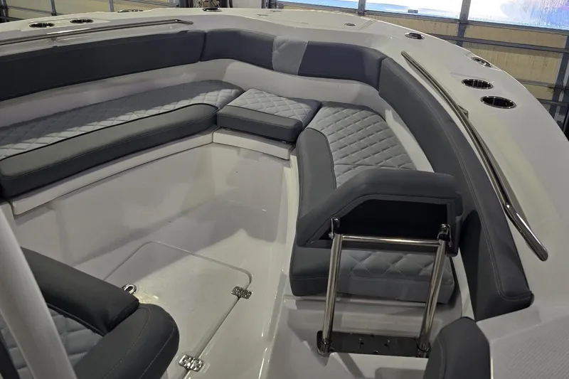 Slide: The Image of 2026 NauticStar 222 Offshore boat interior with gray cushioned seating and stainless steel railings. - 20