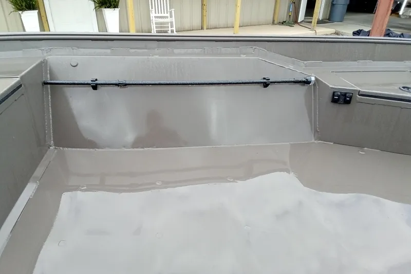 Slide: The Image of 2025 Alweld 1548 Invader boat in outdoor storage, surrounded by other boats and equipment. - 10