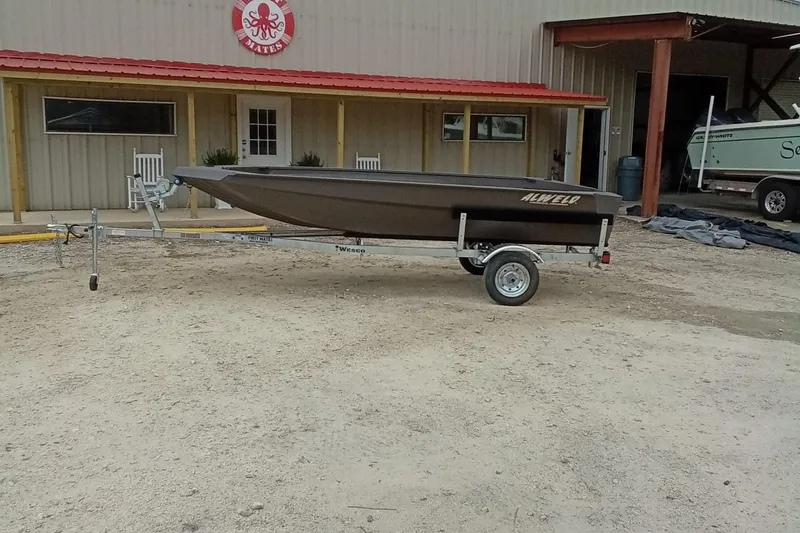 Slide: The Image of 2025 Alweld 1548 Invader boat on trailer outside a building under a clear sky. - 3