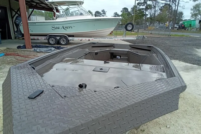 Slide: The Image of 2025 Alweld 1548 Invader boat with spacious deck, parked outdoors. - 7