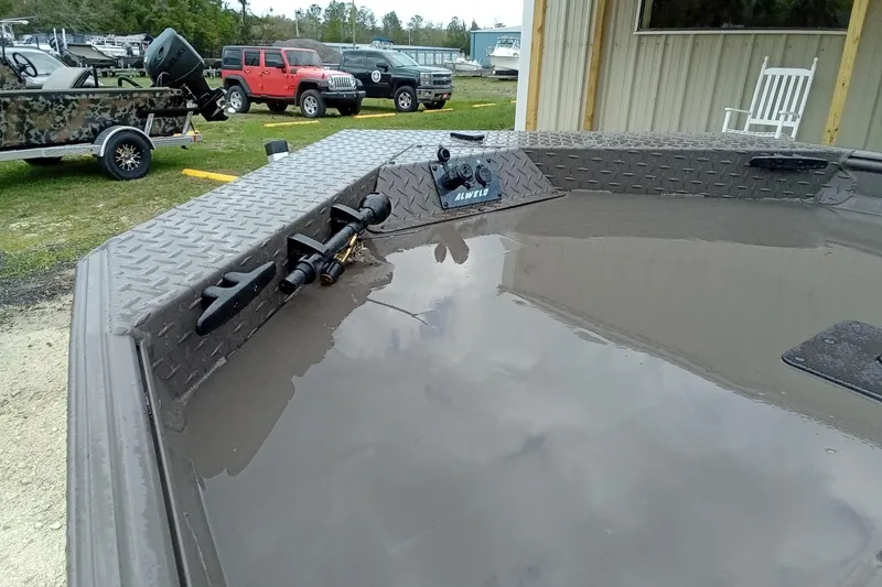 Slide: The Image of 2025 Alweld 1548 Invader boat with Tohatsu outboard motor, parked outdoors. - 8