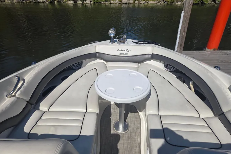 Slide: The Image of 2006 Sea Ray 290 Select EX boat interior with seating and table on calm water. - 16