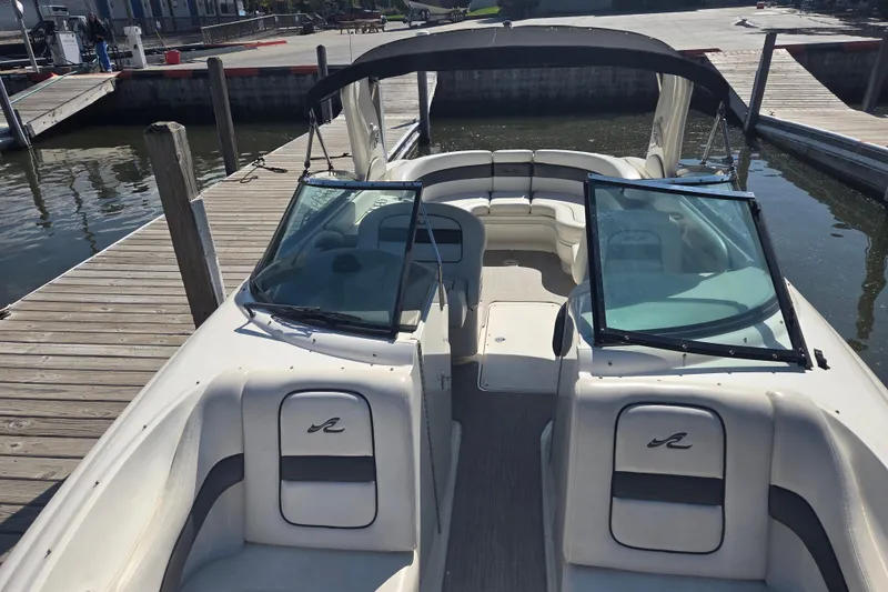Slide: The Image of 2006 Sea Ray 290 Select EX boat docked at marina, featuring open seating and sleek design. - 18
