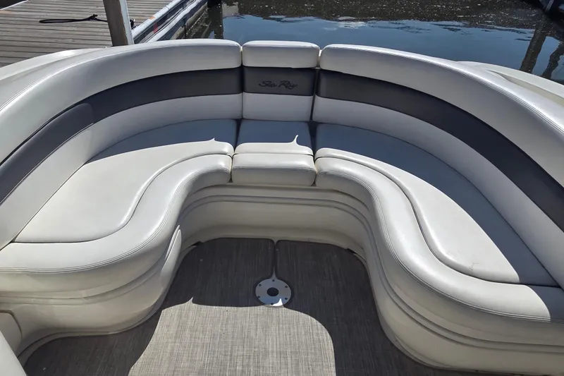 Slide: The Image of 2006 Sea Ray 290 Select EX boat with curved seating, docked by the water. - 25