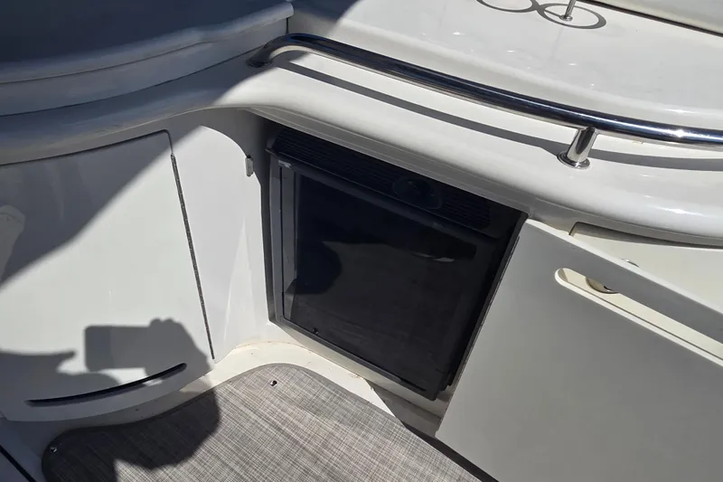 Slide: The Image of 2006 Sea Ray 290 Select EX boat interior with mini fridge and storage compartments. - 30