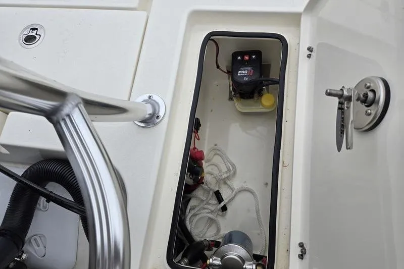 Slide: The Image of 2025 Hewes 16 Redfisher boat compartment with battery and ropes. - 12