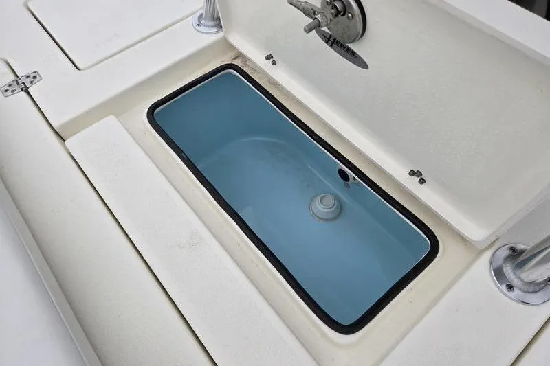 Slide: The Image of 2025 Hewes 16 Redfisher boat livewell with open lid, showcasing interior design. - 13