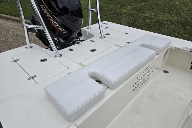 Slide: The Image of 2025 Hewes 16 Redfisher boat with white seating and outboard motor. - 9