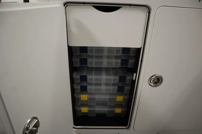 Slide: The Image of Storage compartment on 2026 Yamaha Boats 255 FSH Sport E, featuring organized tackle boxes. - 20