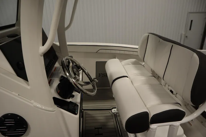 Slide: The Image of Interior of 2026 Yamaha Boats 255 FSH Sport E, featuring steering wheel and seating. - 25