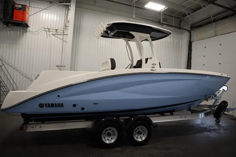 Slide: The Image of 2026 Yamaha Boats 255 FSH Sport E in a showroom, side view. - 3