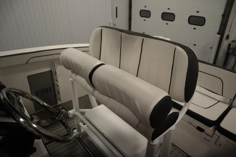 Slide: The Image of 2026 Yamaha Boats 255 FSH Sport E interior with sleek seating and steering wheel. - 36