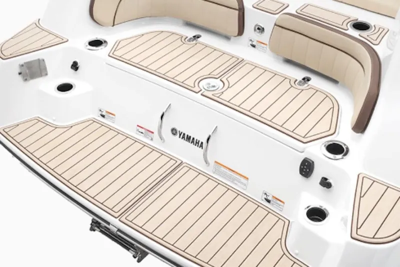 Slide: The Image of 2026 Yamaha Boats 255 FSH Sport E deck with beige seating and cup holders. - 57