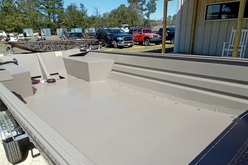 Slide: The Image of 2025 Alweld 1648VV Marsh boat, spacious interior, parked outdoors near a building. - 16