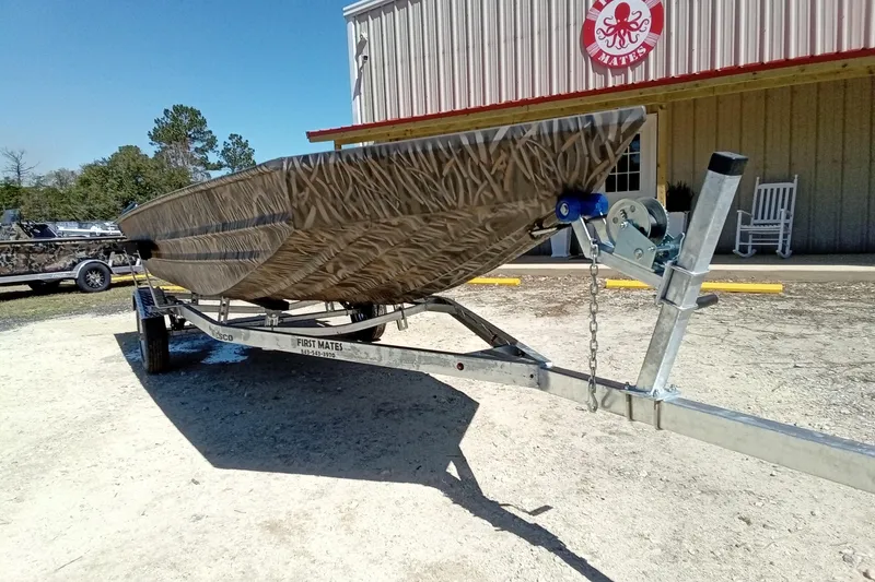 Slide: The Image of 2025 Alweld 1648VV Marsh boat on trailer outside a building. - 3
