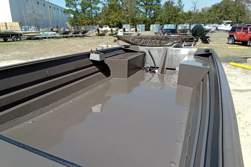 Slide: The Image of 2025 Alweld 1648VV Marsh boat interior, parked outdoors with other boats and vehicles. - 5