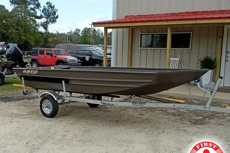 The Image of 2025 Alweld 1548VV Marsh boat on trailer, parked outside a building. - 1