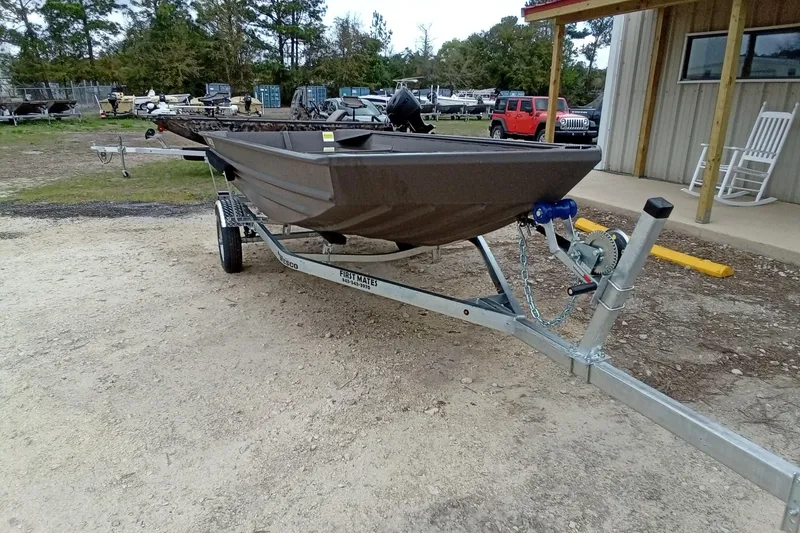 Slide: The Image of 2025 Alweld 1548VV Marsh boat on trailer, parked outdoors near a building. - 4