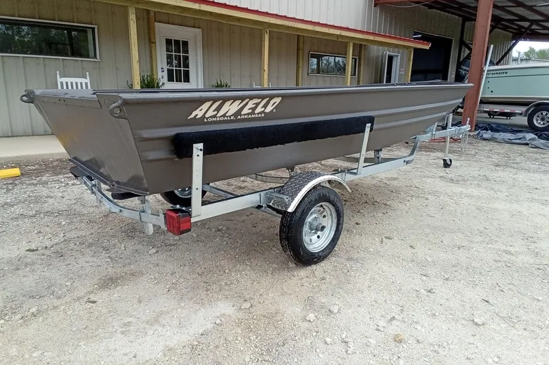 Slide: The Image of 2025 Alweld 1548VV Marsh boat on trailer, parked outside a building. - 8