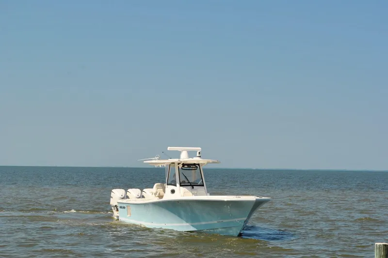 Slide: The Image of 2025 Regulator 34 Center Console boat cruising on open water under clear blue sky. - 14