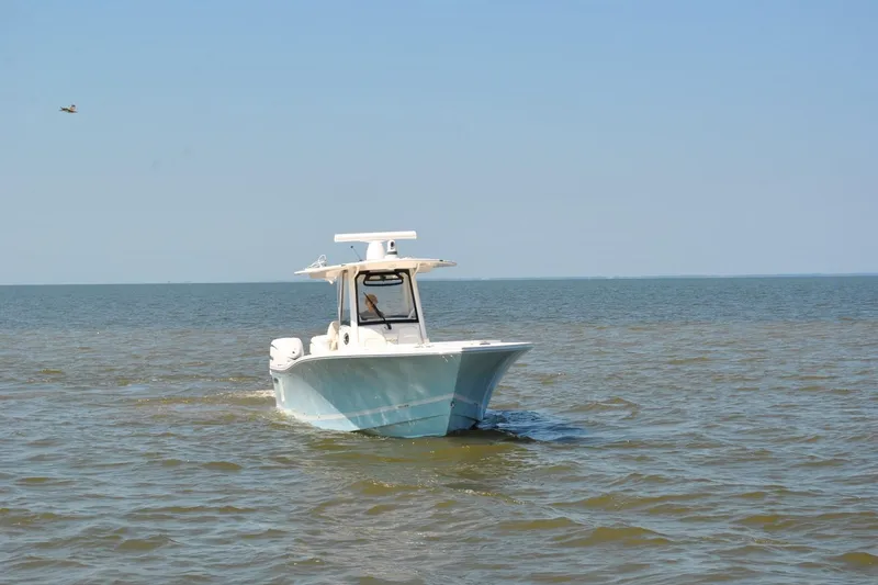 Slide: The Image of 2025 Regulator 34 Center Console boat cruising on open water under clear blue sky. - 15