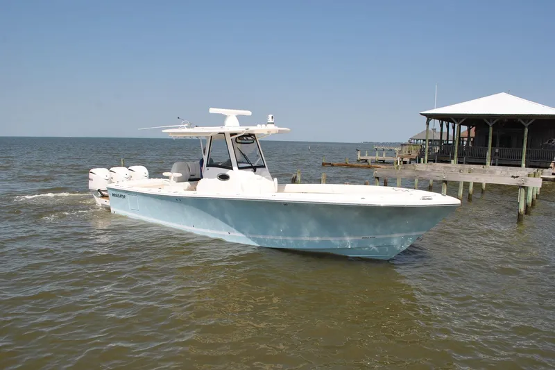 Slide: The Image of 2025 Regulator 34 Center Console boat on water near dock, clear sky background. - 22
