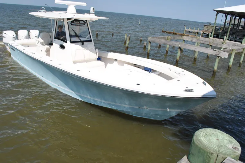 Slide: The Image of 2025 Regulator 34 Center Console boat docked on calm waters. - 23