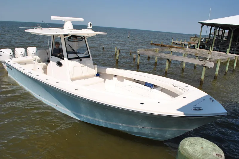 Slide: The Image of 2025 Regulator 34 Center Console boat docked on calm waters. - 24