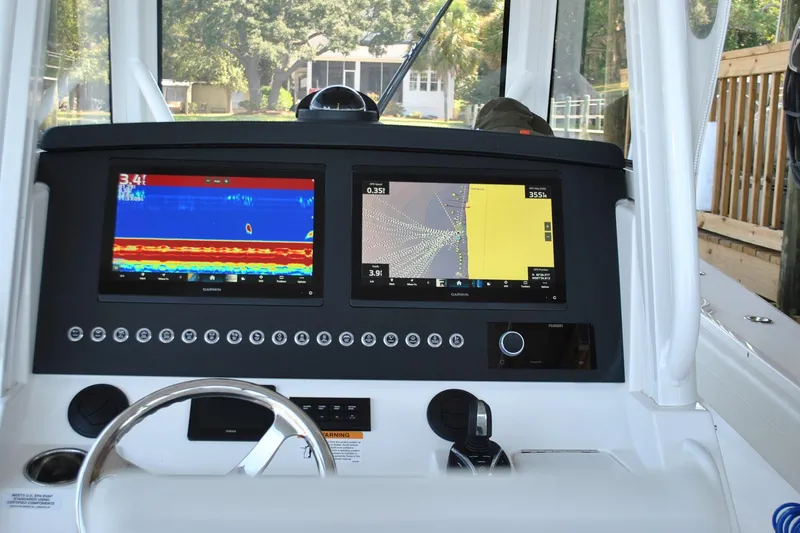 Slide: The Image of 2025 Regulator 34 Center Console dashboard with dual Garmin displays and steering wheel. - 30