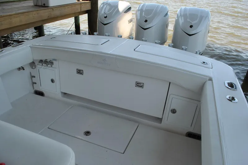 Slide: The Image of 2025 Regulator 34 Center Console boat with triple outboard engines docked by the water. - 37