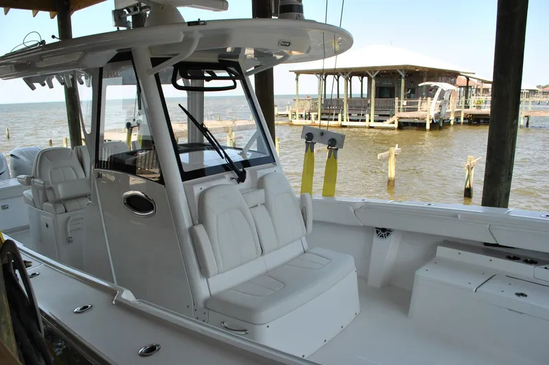 Slide: The Image of 2025 Regulator 34 Center Console boat docked by a waterfront pavilion. - 47