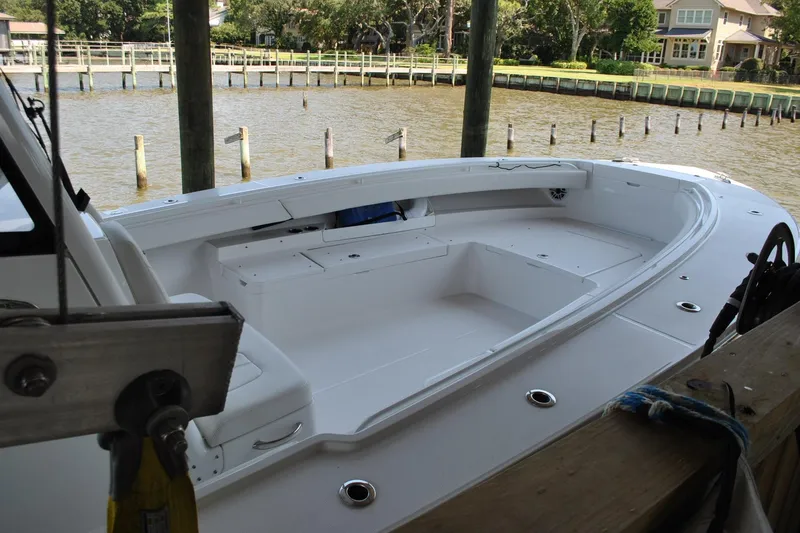 Slide: The Image of 2025 Regulator 34 Center Console boat docked by a scenic waterfront. - 48