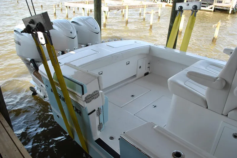 Slide: The Image of 2025 Regulator 34 Center Console boat with dual engines docked by the water. - 49