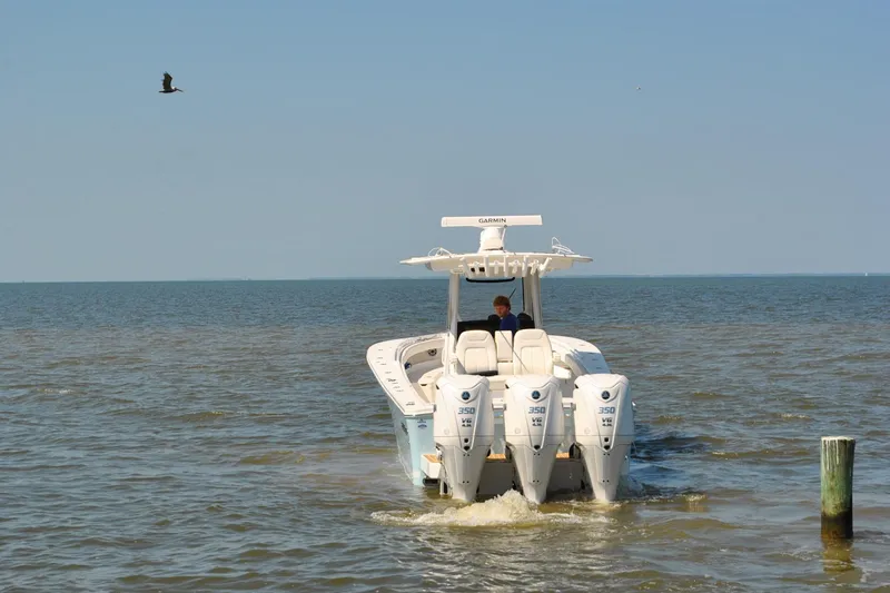 Slide: The Image of 2025 Regulator 34 Center Console boat with triple engines on open water. - 7