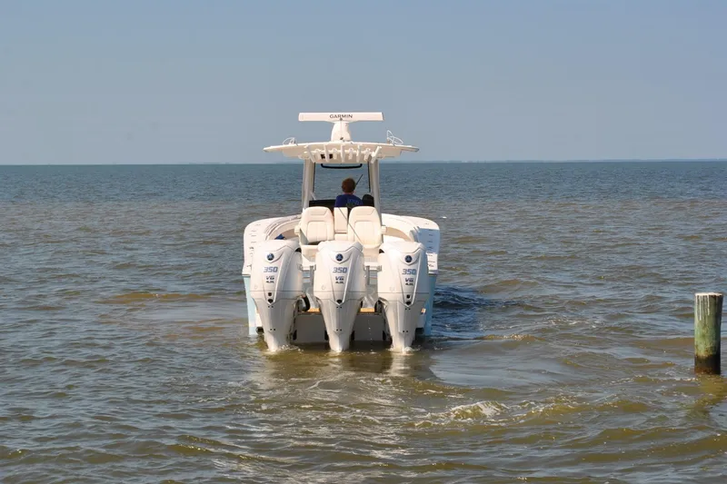 Slide: The Image of 2025 Regulator 34 Center Console boat with triple engines on open water. - 8