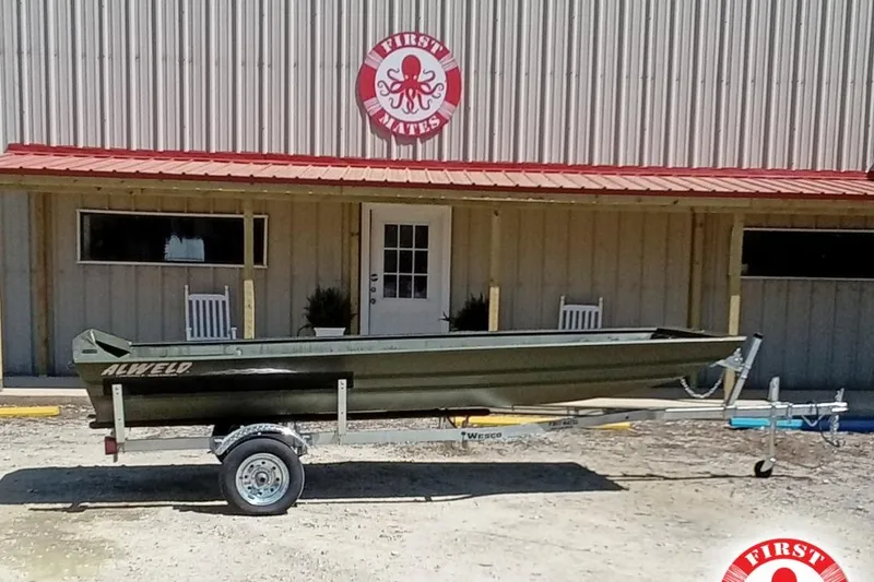 The Image of 2025 Alweld 1542 Flat Marsh boat on trailer outside a building with red roof. - 1