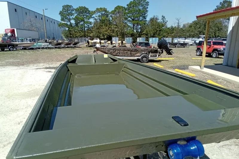 Slide: The Image of 2025 Alweld 1542 Flat Marsh boat in outdoor lot, surrounded by vehicles and trees. - 6