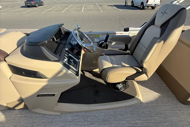 Slide: The Image of Captain's seat and helm of 2026 Berkshire 23RFX STS pontoon boat in a parking lot. - 37