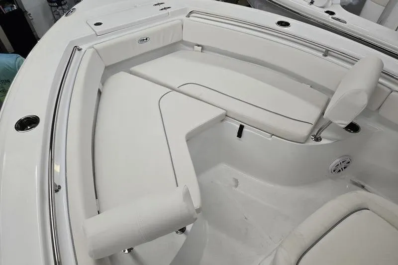 Slide: The Image of 2026 Sea Hunt Ultra 219 boat interior with white cushioned seating and stainless steel accents. - 17