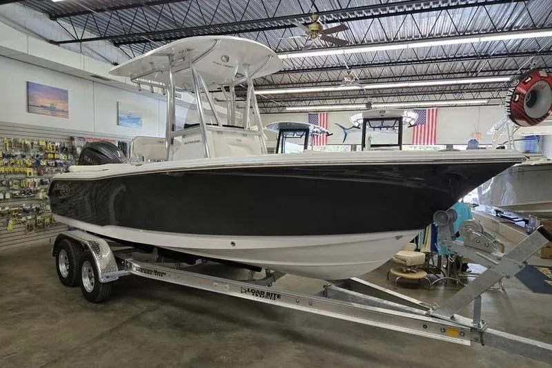 The Image of 2026 Sea Hunt Ultra 219 boat on trailer in showroom. - 2