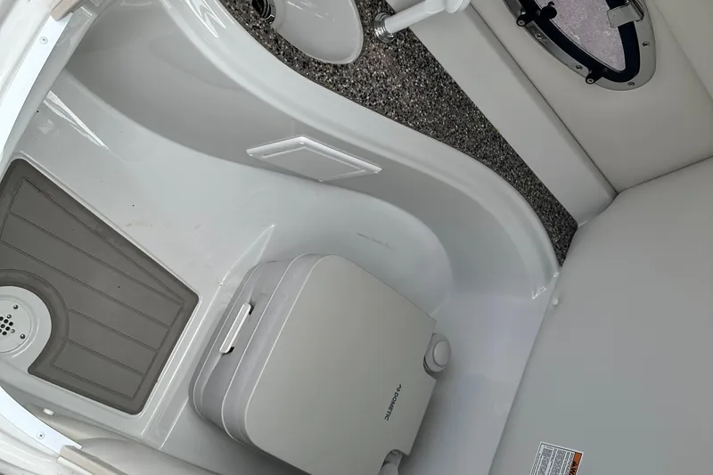 Slide: The Image of 2021 Crownline Eclipse E235 SURF boat interior with compact toilet and flooring. - 12