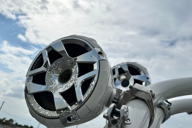 Slide: The Image of Close-up of speakers on a 2021 Crownline Eclipse E235 SURF boat under a cloudy sky. - 17