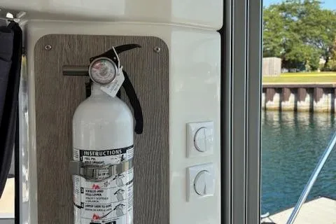 Slide: The Image of 2024 Bayliner Trophy T25 Explorer interior with mounted fire extinguisher by a window. - 10