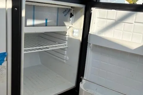 Slide: The Image of Open refrigerator inside 2024 Bayliner Trophy T25 Explorer boat, showcasing interior space. - 14