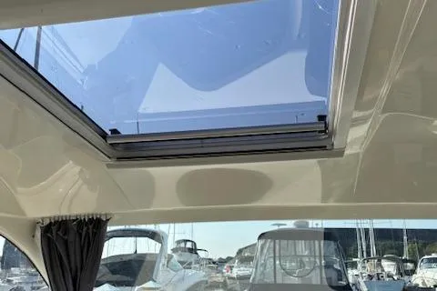 Slide: The Image of 2024 Bayliner Trophy T25 Explorer interior with sunroof and marina view. - 16