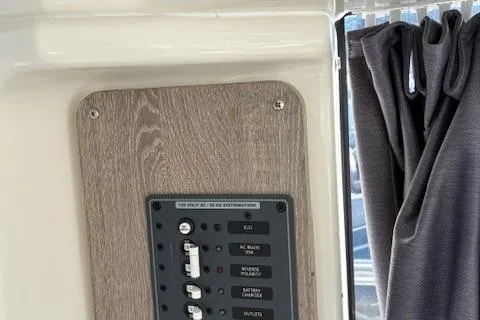 Slide: The Image of 2024 Bayliner Trophy T25 Explorer control panel with switches and curtain detail. - 18