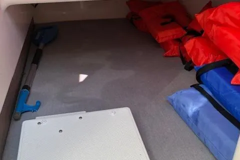 Slide: The Image of 2024 Bayliner Trophy T25 Explorer storage area with life jackets and paddle. - 20