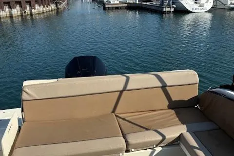 Slide: The Image of 2024 Bayliner Trophy T25 Explorer boat with tan seating at a marina. - 26